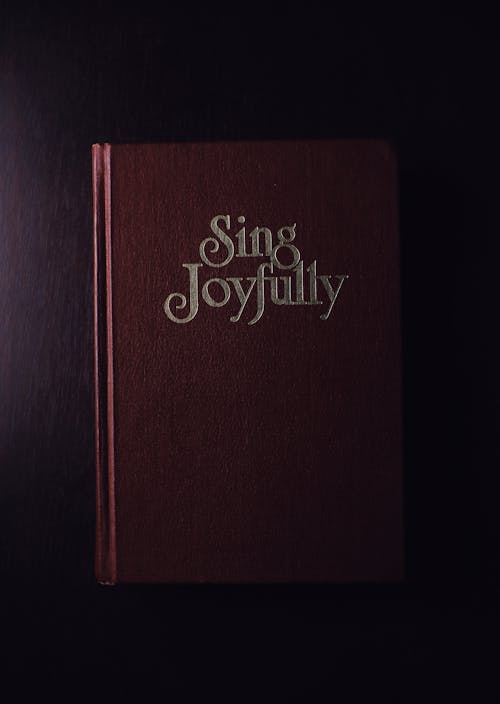 Free From above of book with collection of songs placed on black surface in studio Stock Photo