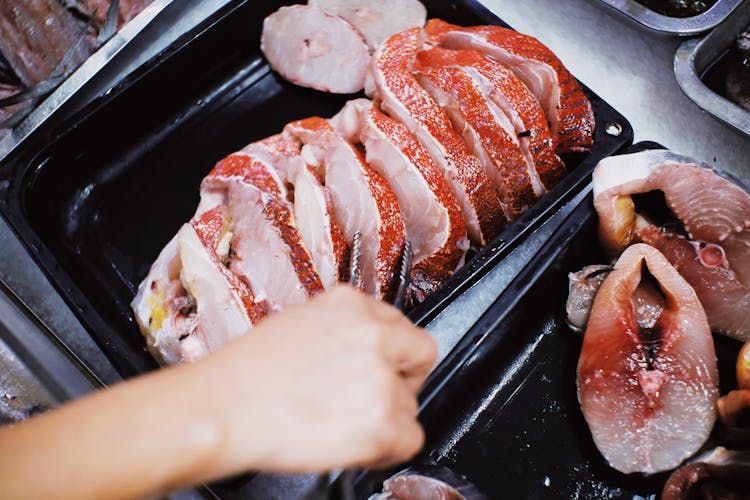 Person Taking Steak Of Fresh Fish