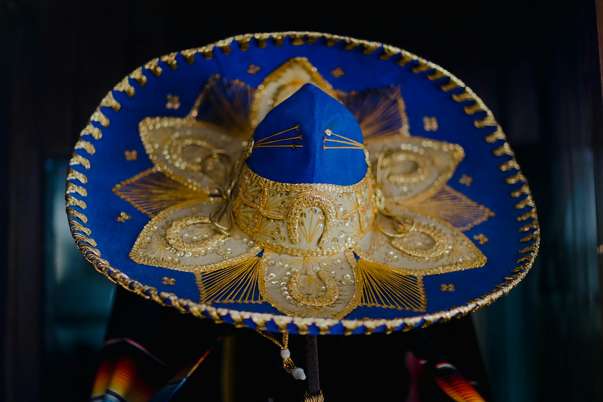 A beautifully detailed Mexican sombrero showcasing intricate gold embroidery and vibrant colors.