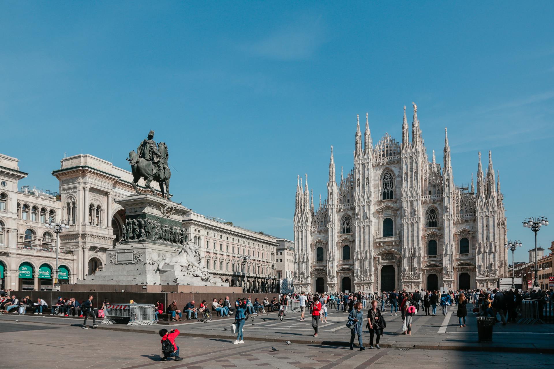 Capture of Milan's iconic Duomo di Milano with vibrant city life in Piazza del Duomo.