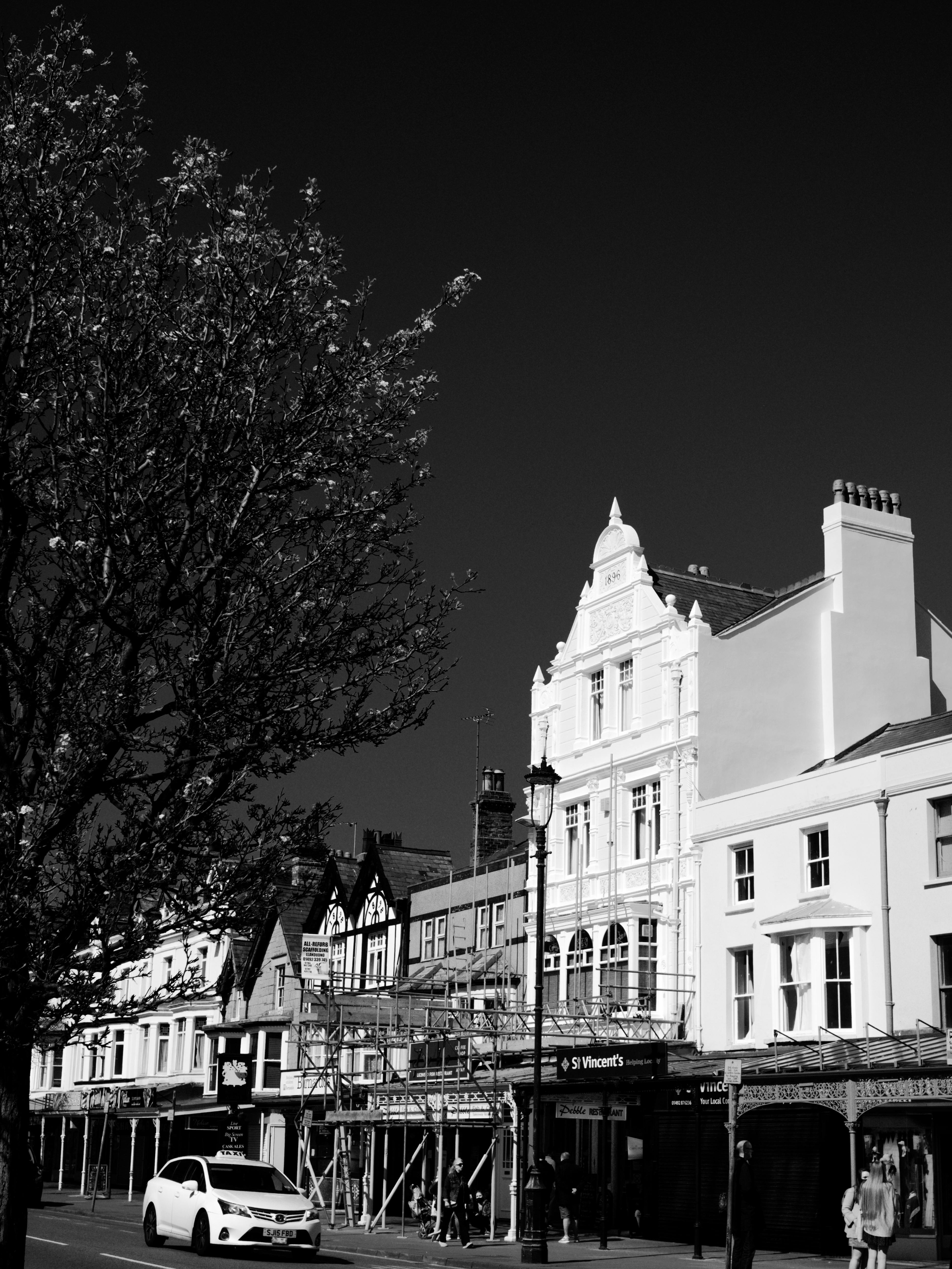 Monochrome view of Llandudno's classic Victorian architecture under a dark sky.