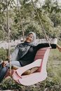 Woman in Black Hijab Sitting on Swing