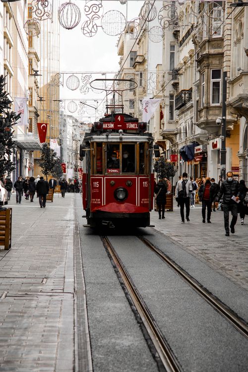 Free A classic red tram travels along the bustling İstiklal Avenue in Istanbul, surrounded by pedestrians. Stock Photo