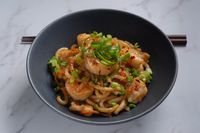 Thick yellow noodles tossed with prawns and spring onion — photo by Max Griss on Pexels