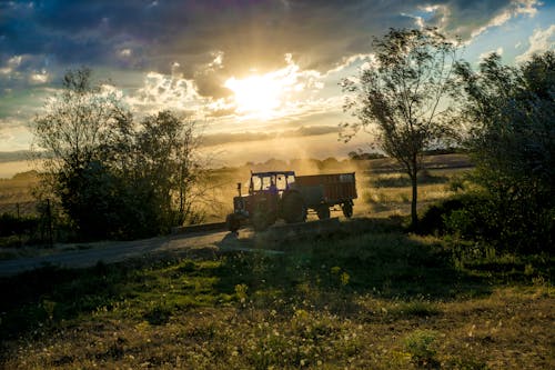 Tractor With Trailer Under Cloudy Skies during Day