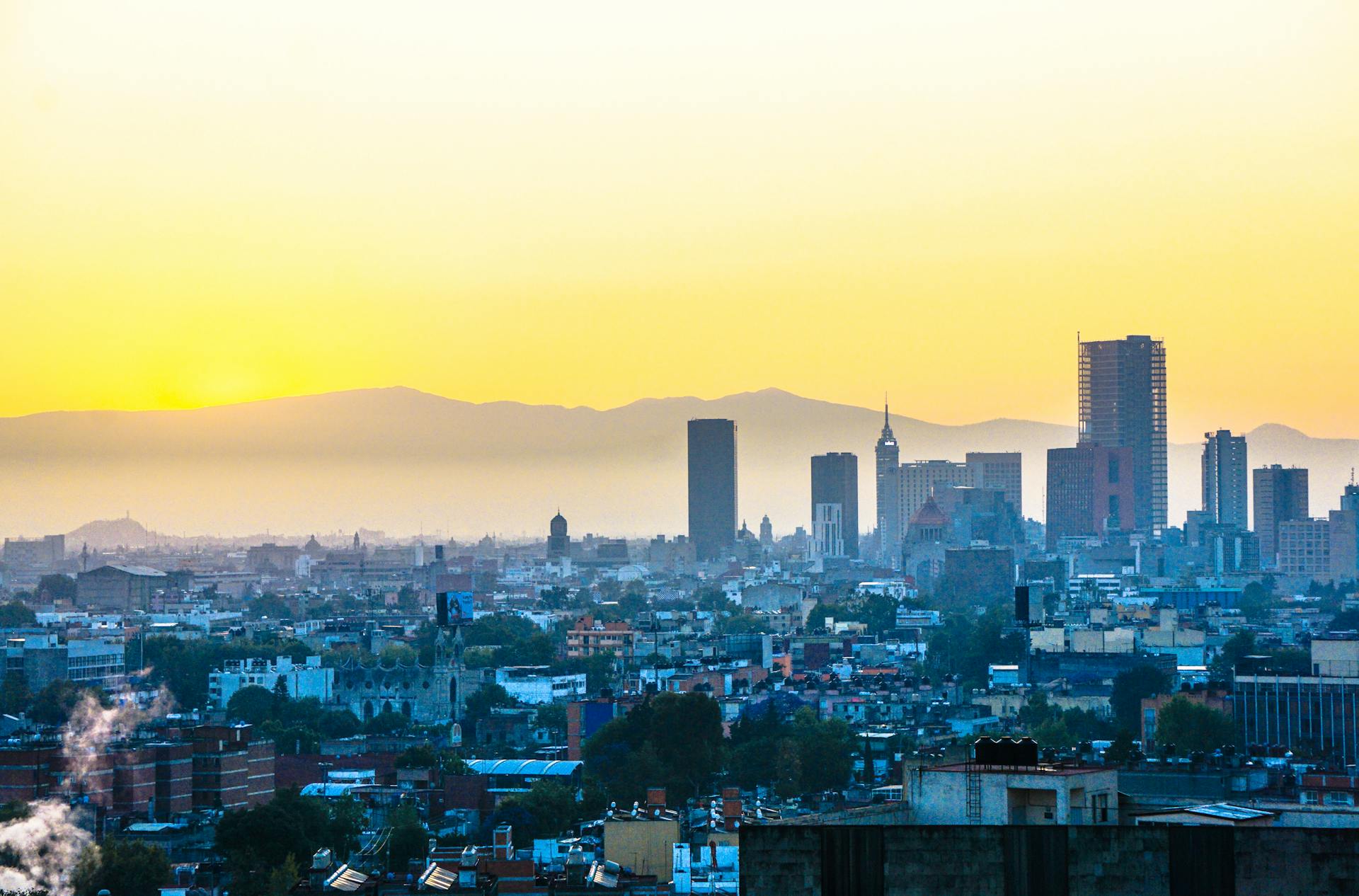 Vibrant Mexico City skyline against a colorful sunrise backdrop with iconic skyscrapers.