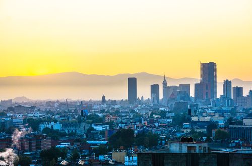 Free Vibrant Mexico City skyline against a colorful sunrise backdrop with iconic skyscrapers. Stock Photo