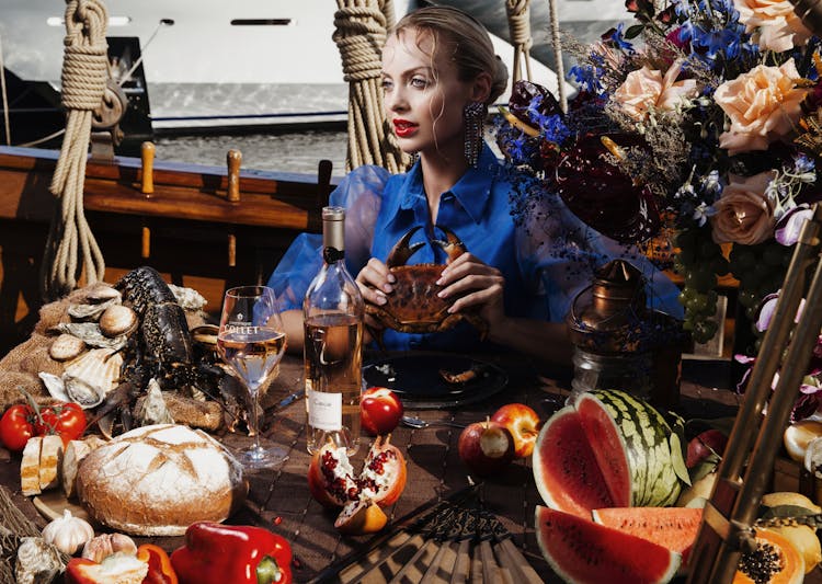 Stylish Woman At Table With Food On Boat