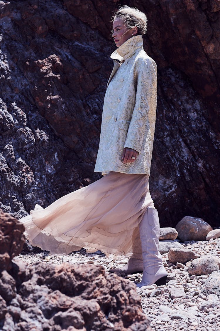 Woman In Suit And Skirt Among Rocks