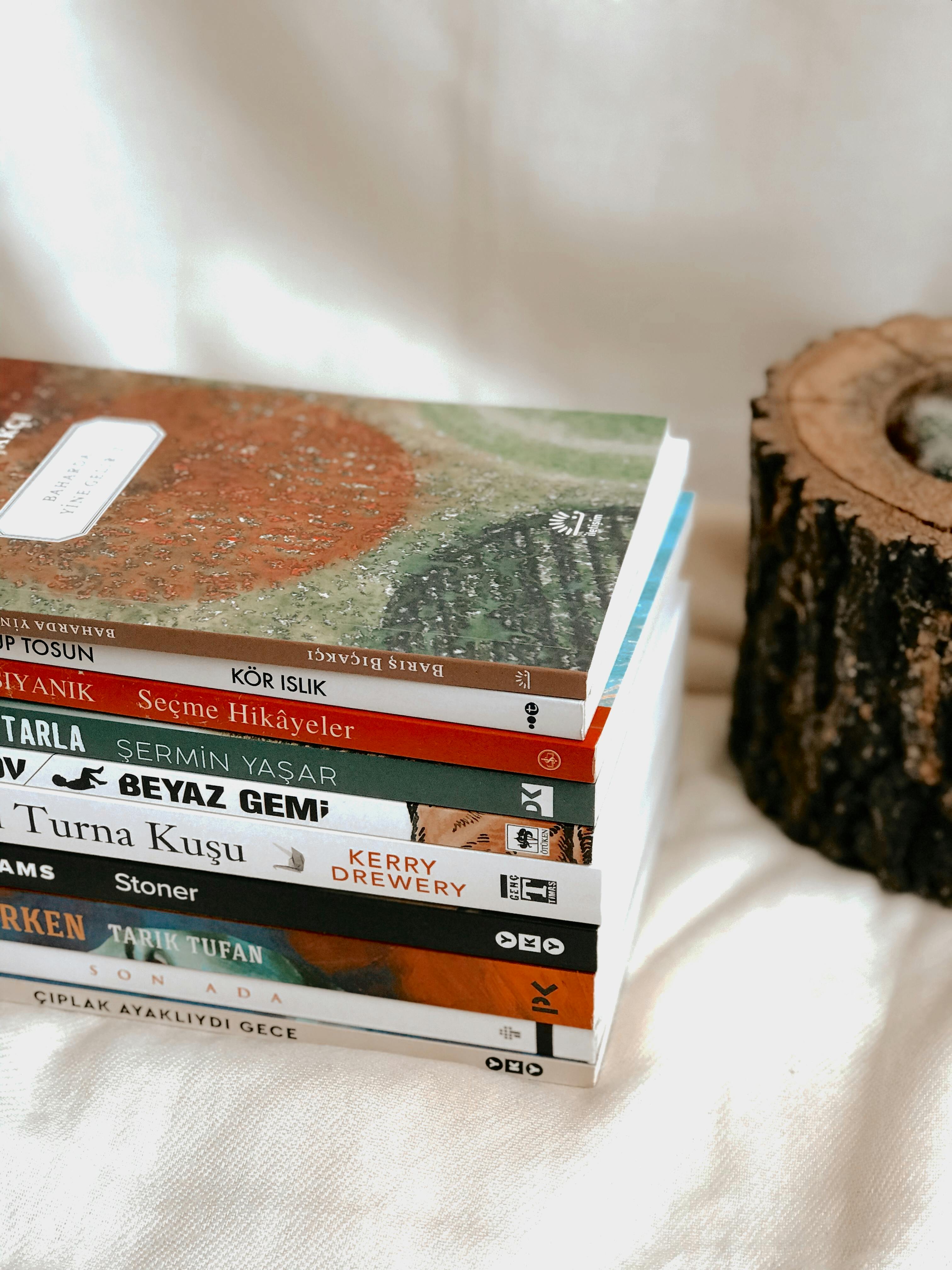 A close-up of a stack of Turkish books beside a wooden decoration.