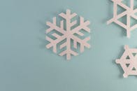 淡蓝色背景上点缀着优雅的纸雪花，非常适合冬季或假日装饰