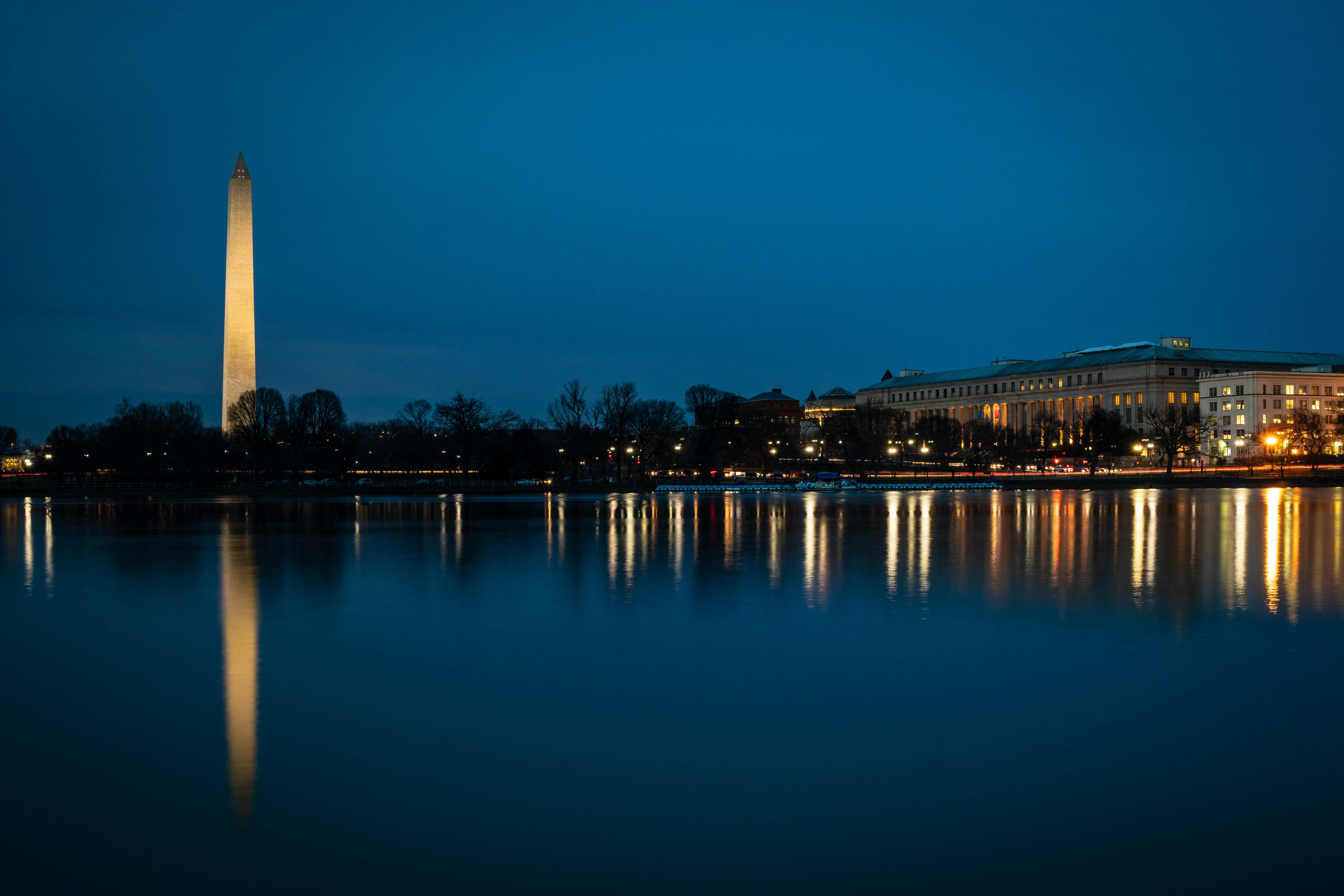 Stunning night view of the Washington Monument reflecting in the Tidal Basin with city lights.