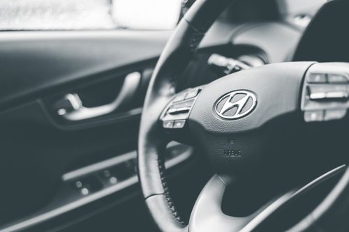 Free Grayscale close-up of Hyundai car steering wheel, highlighting brand interior design. Stock Photo