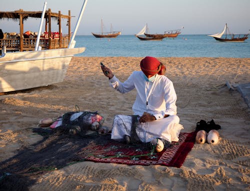 Free Man in White Thobe Sitting on Brown Sand Stock Photo