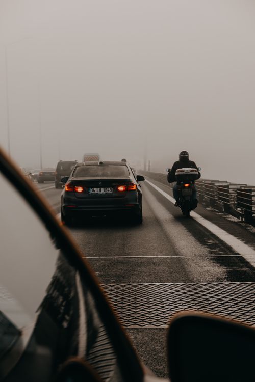 Free A misty highway scene with cars and a motorbike in traffic, emphasizing travel and transportation. Stock Photo
