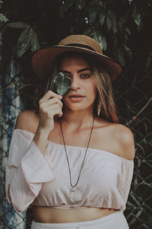Free Woman in Crop Top Holding Leaf Covering Right Eye Stock Photo