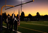 运动场上充满活力的日落与美国国旗仪式，增添了爱国的气息
