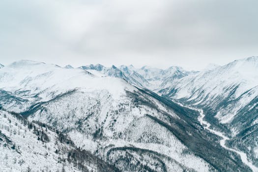 Aerial view of snow-covered mountains showcasing untouched wilderness and majestic peaks in winter.
