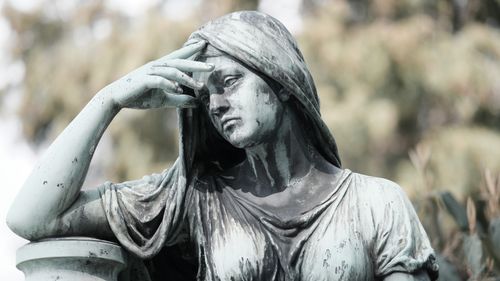 Free Close-up of a contemplative statue in Aachen, Germany, with a blurred natural backdrop. Stock Photo