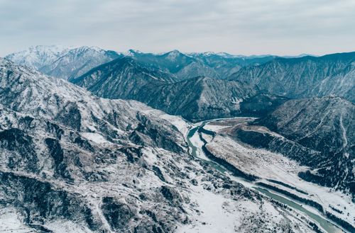 Free Stunning aerial photograph showcasing a snow-covered mountain range with winding river. Stock Photo