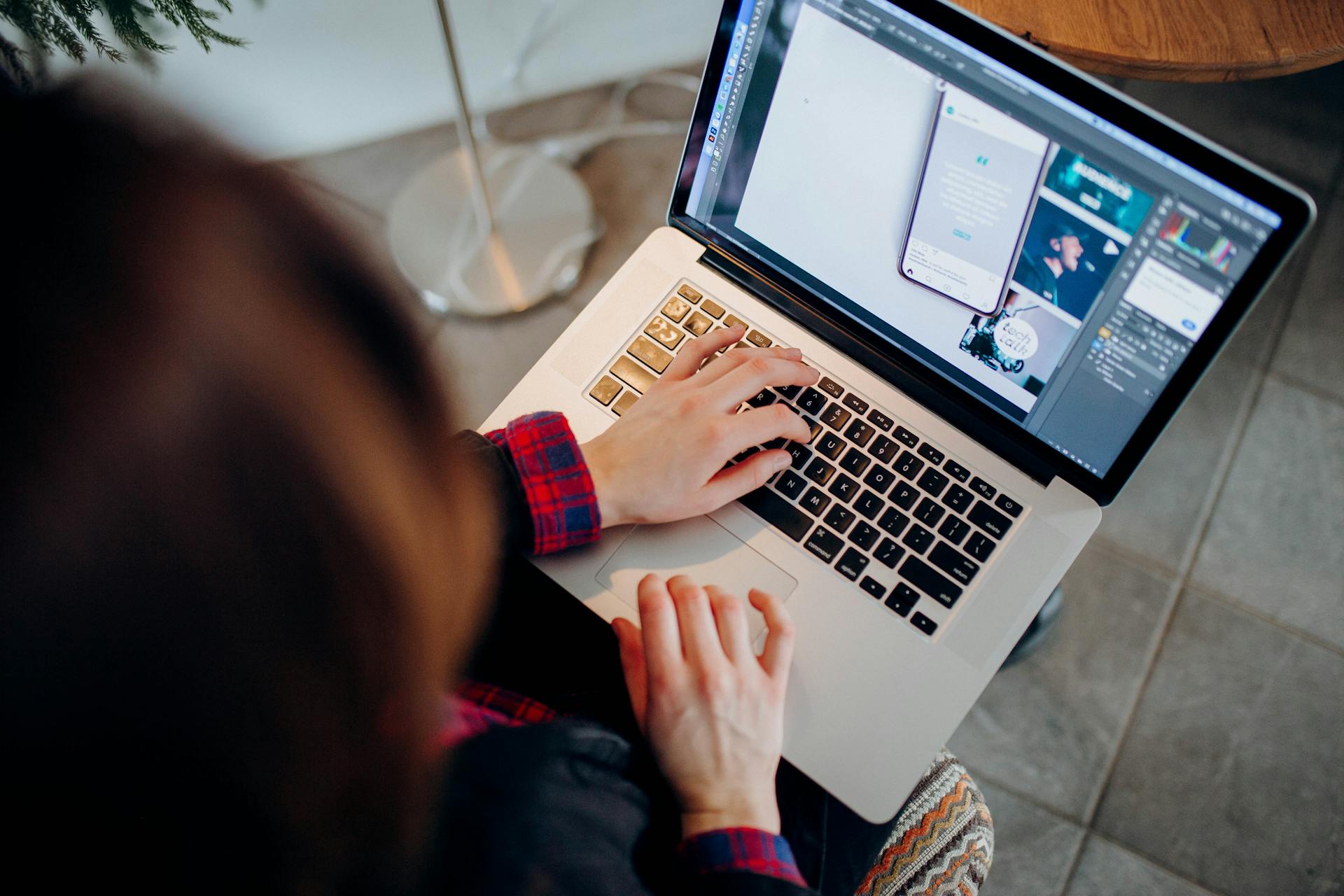 Close-up of a person working on a laptop with graphic design software.