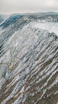 Stunning aerial view of a snow-covered mountain landscape in Ulaganskiy Rayon, Altai Republic, Russia.