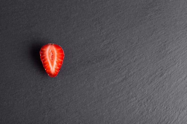 A Half Strawberry On Gray Rough Surface