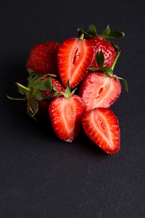 Sliced Strawberries on Black Surface
