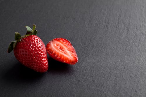 Free A Whole and Sliced Strawberries on Grey Background Stock Photo