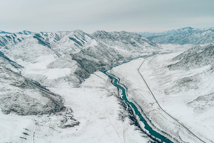 Aerial View Of A Valley Between Snow Covered Mountains