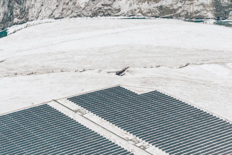 Aerial View Of Solar Power Plant On Snow Covered Field During Winter