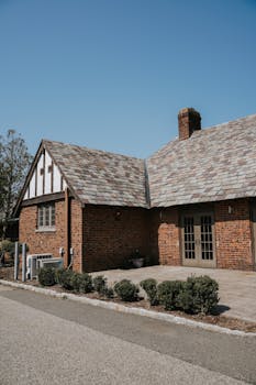 Charming Tudor-style brick house with beautiful slate roof, perfect for real estate inspiration.