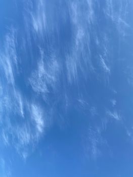 Photo featuring a clear blue sky with light, wispy clouds creating a serene atmosphere.