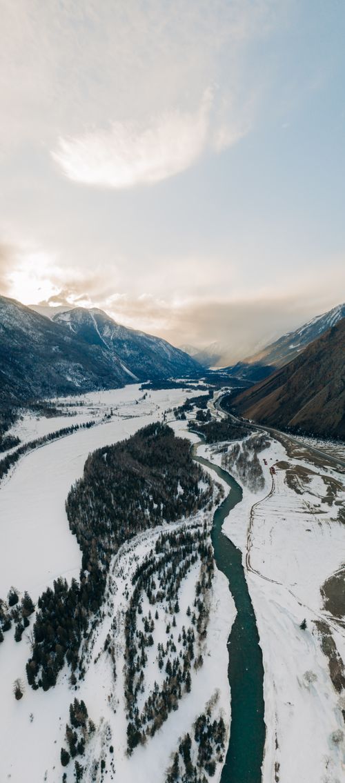 Free Stunning aerial view of snow-covered mountains and river in Altai, capturing winter's natural beauty. Stock Photo