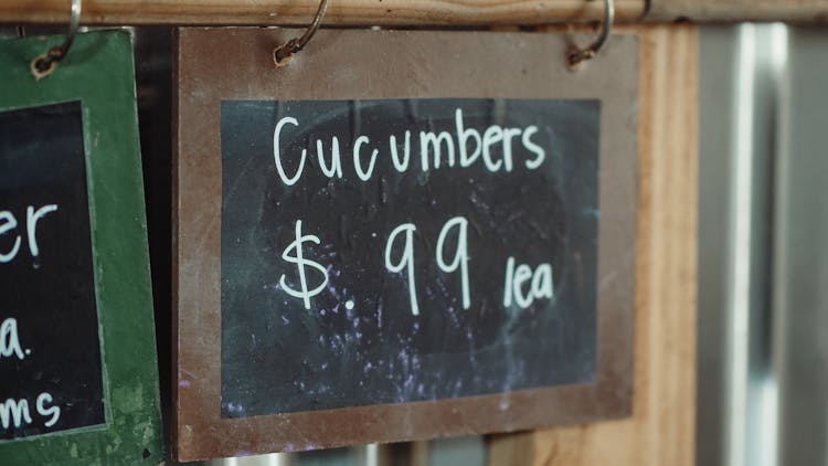 A Wooden Chalkboard With Cucumber Price On Display