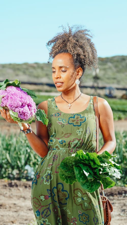 A Woman in Green Dress Holding Vegetables