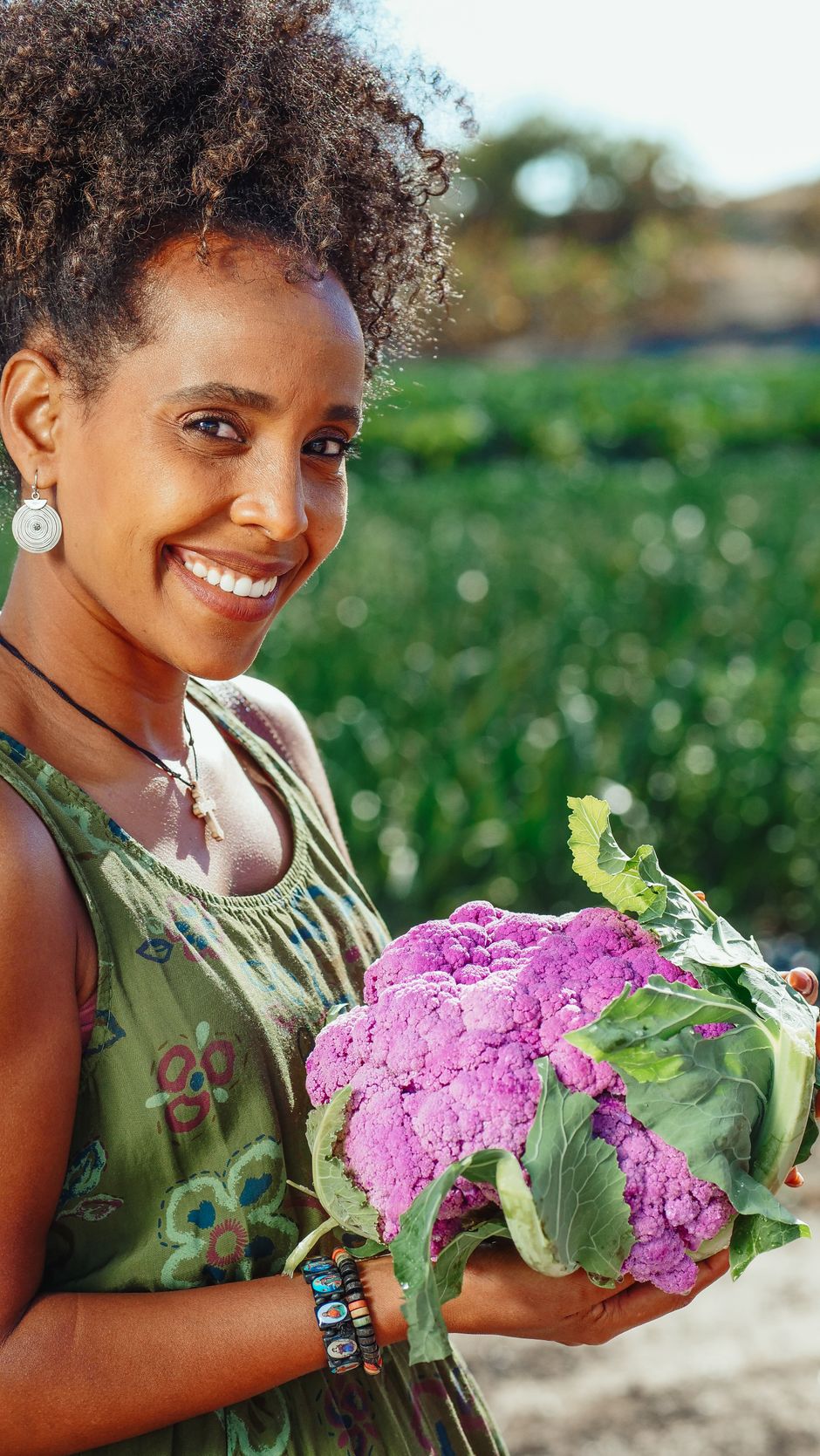 Smiling woman holding a fresh purple cauliflower
