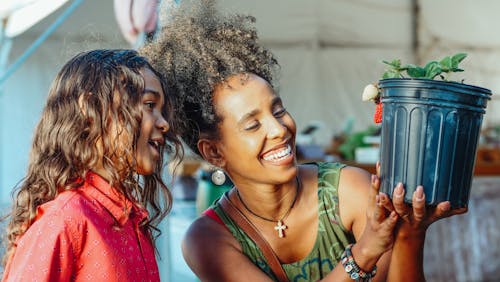 A Mother and Daughter Looking a Strawberry in Pot