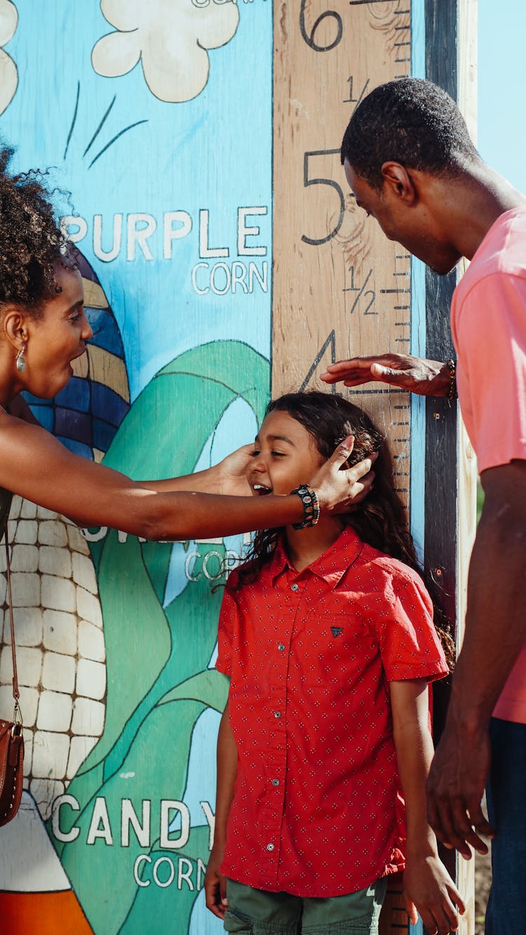 Parents Measuring Their Child's Height