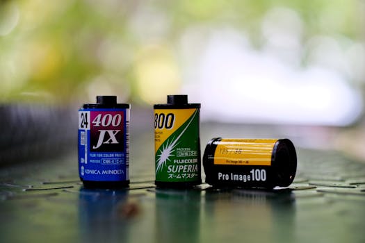 Detailed close-up of three different color film rolls on a reflective surface.