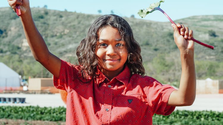 Smiling Black Girl With Beet Leaf On Plantation