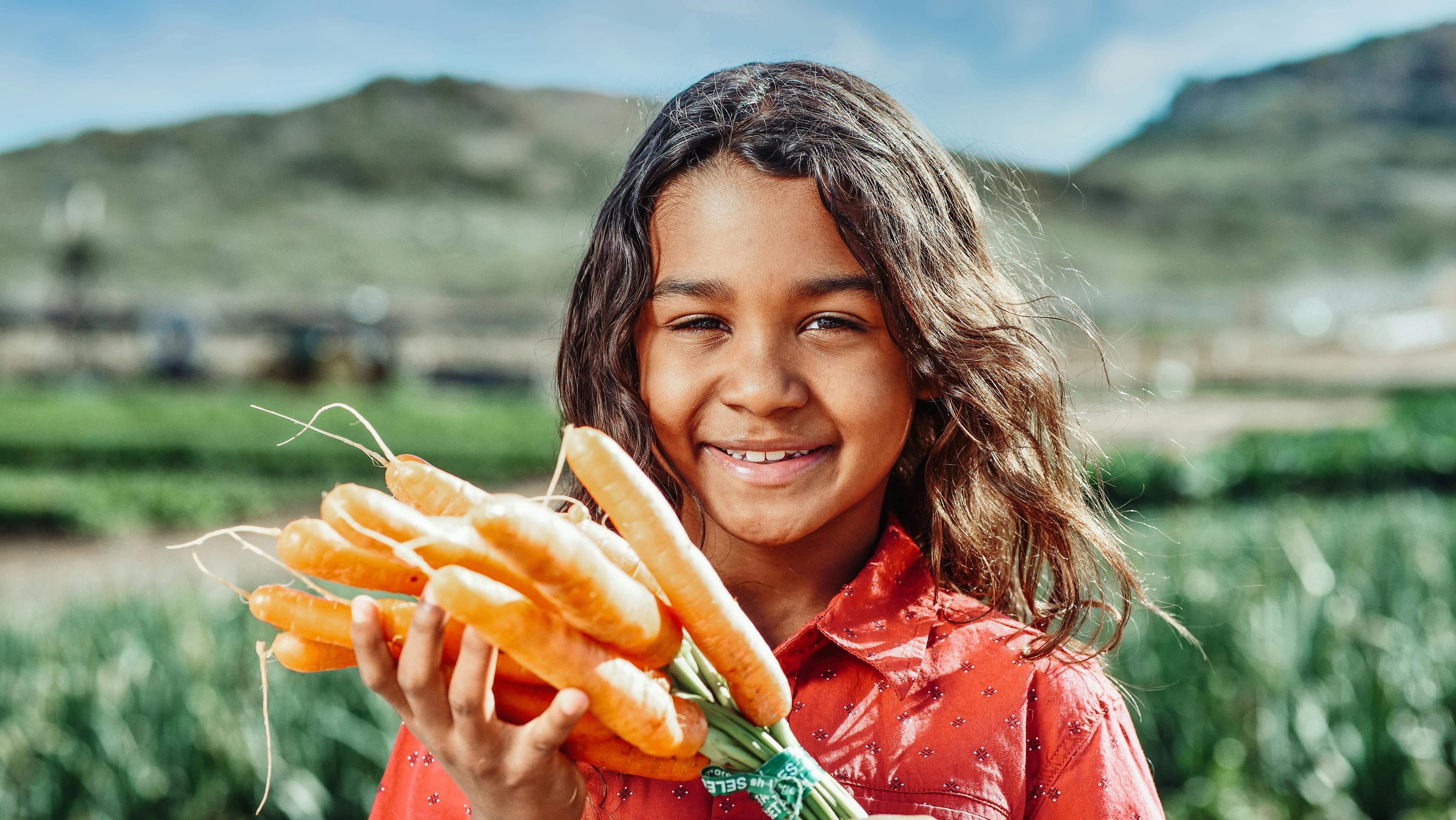 Little Girl Munching On A Carrot Stick Holding Bowl Of Vegetables Stock  Photo, Picture and Royalty Free Image. Image 11411207.