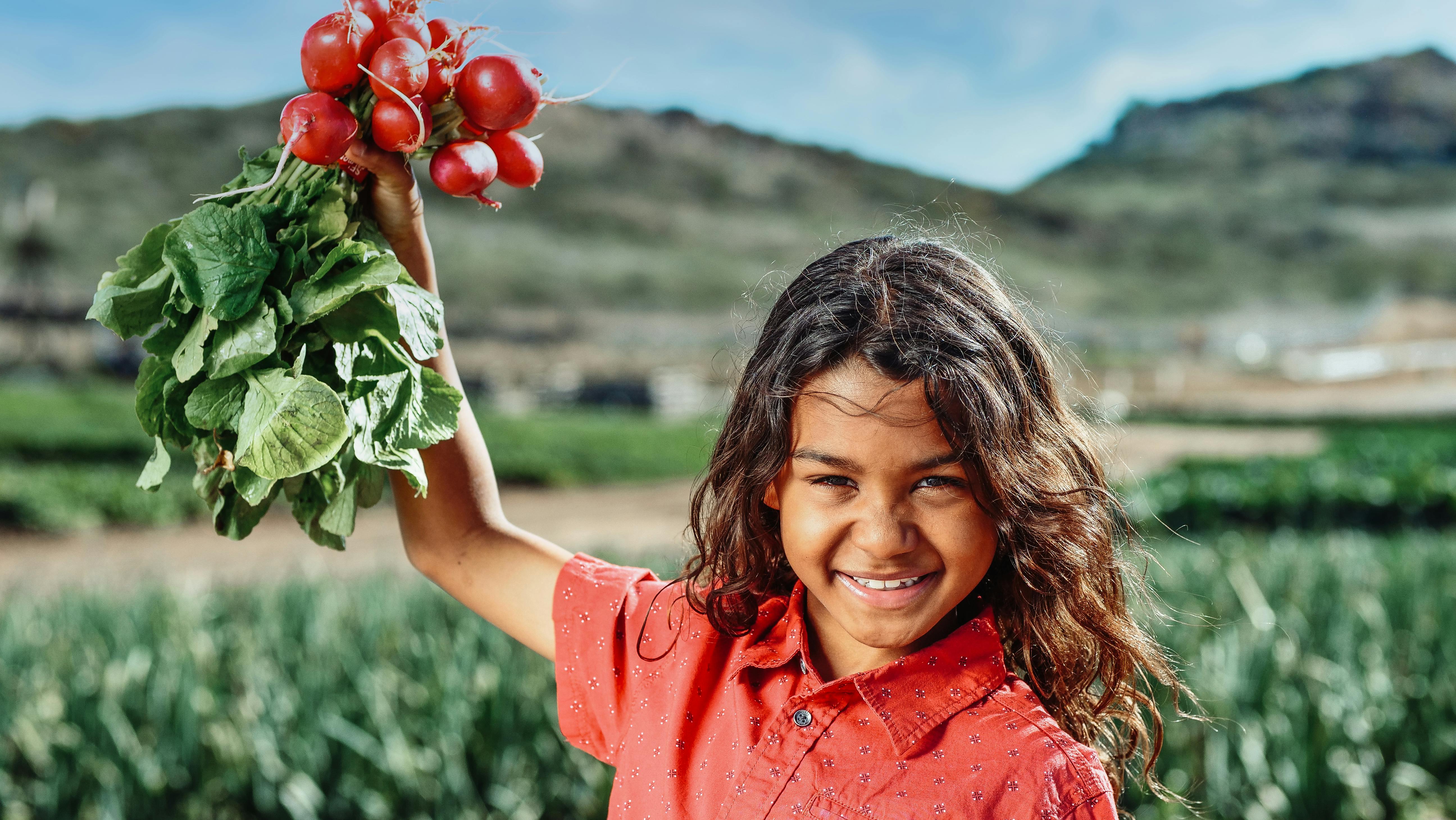 selective focus of a girl holding red radishes