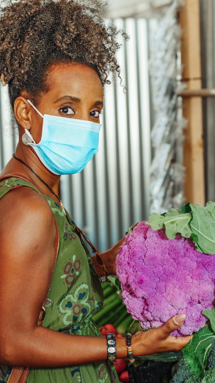 Woman In Face Mask Holding A Purple Broccoli 