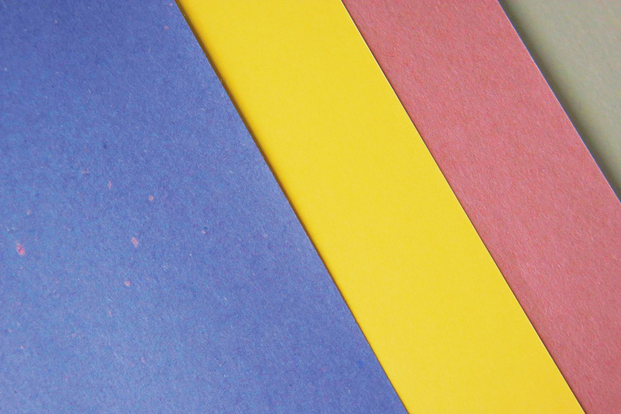 from above of abstract background of textured colorful pieces of paper