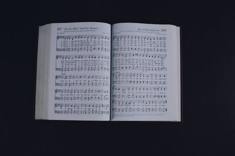 Opened Book With Music Notes Against Dark Background