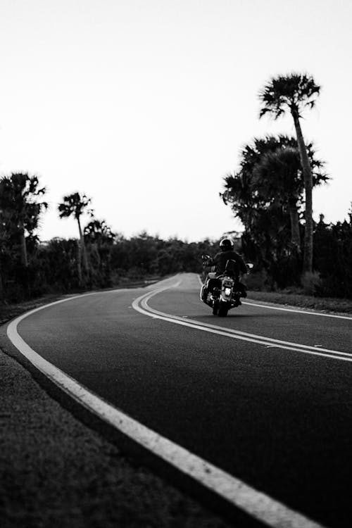 Grayscale Photo of a Person Riding a Motorcycle on the Road