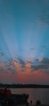 A beautiful sunset with vibrant clouds over a peaceful waterfront; perfect for serene and romantic scenes.