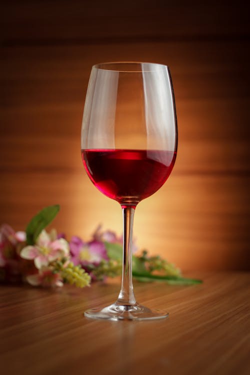 Red Wine in Clear Wine Glass on Wooden Table