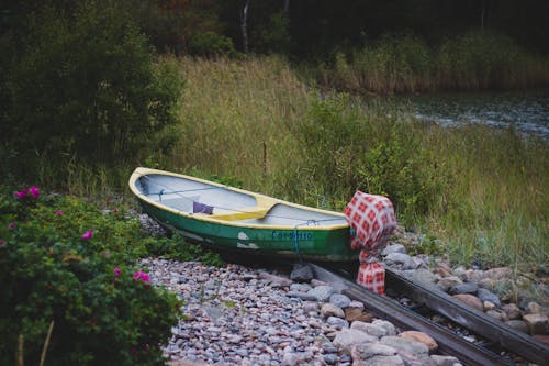 Green and Yellow Canoe Near Lake